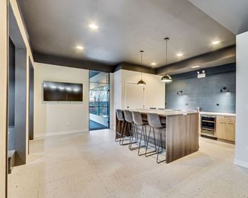 A modern kitchen with a long island and bar stools.